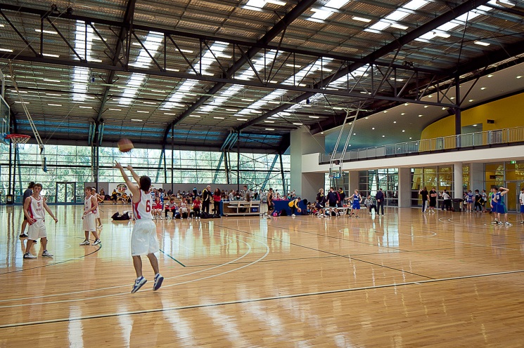 A photo of Perry Lakes Hawks basketball players warming up on court at the Bendat Basketball Centre