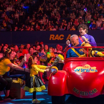 A photo of The Wiggles driving their big red car at RAC Arena in Perth