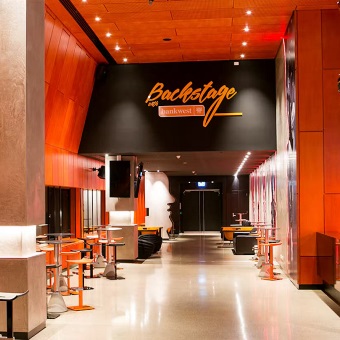 A photo taken of an event space hallway with a sign above saying Backstage with Bankwest at RAC Arena in Perth