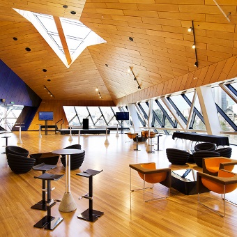 A photo taken of a large open room with very spaced out tables and chairs at RAC Arena in Perth